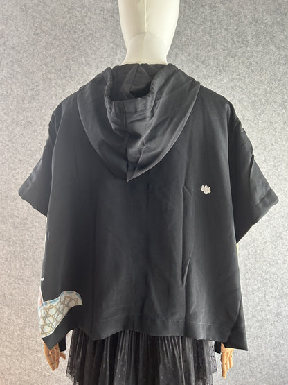 Black hooded kimono poncho with small white crest on back, back view