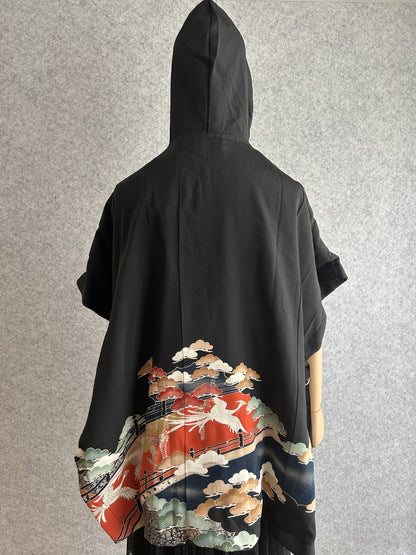Black hooded kimono poncho with red and navy scene at the hem, back view