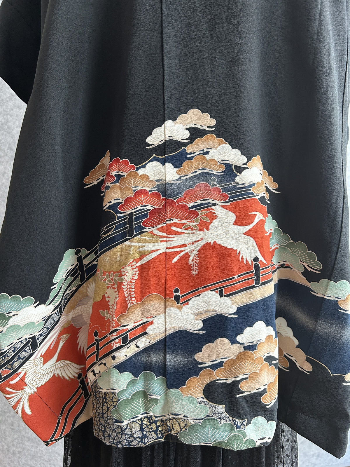 Black hooded kimono poncho, detail of bird and pine scene on the back hem