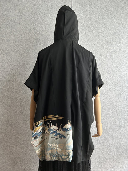 Black hooded kimono poncho with pine and wave scene at the hem, back view