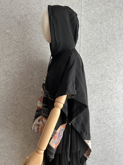 Black hooded kimono poncho with patterned front panels, side view