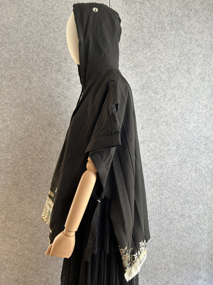 Black hooded kimono poncho with patterned hem, side view