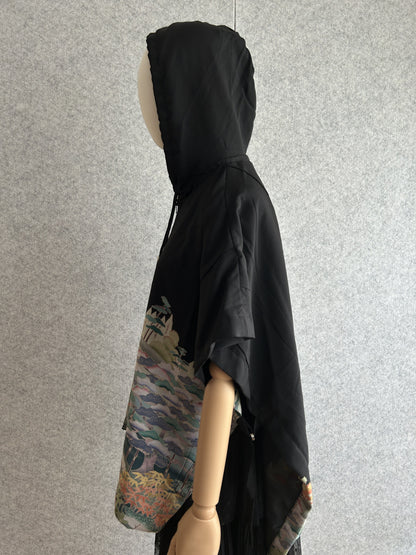 Black hooded kimono poncho with pastel pattern at the hem, side view