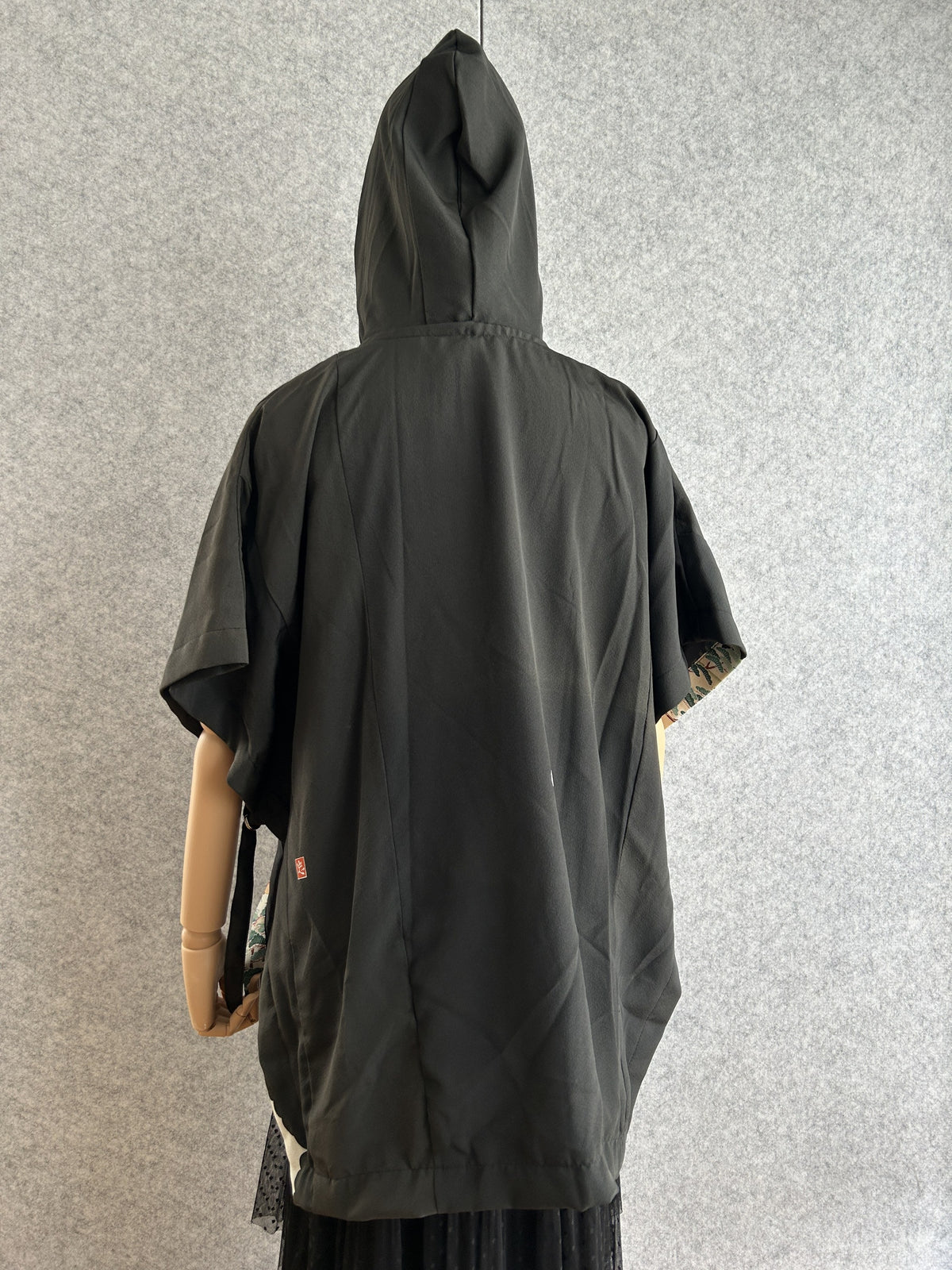 Black hooded kimono poncho, mostly plain black, back view