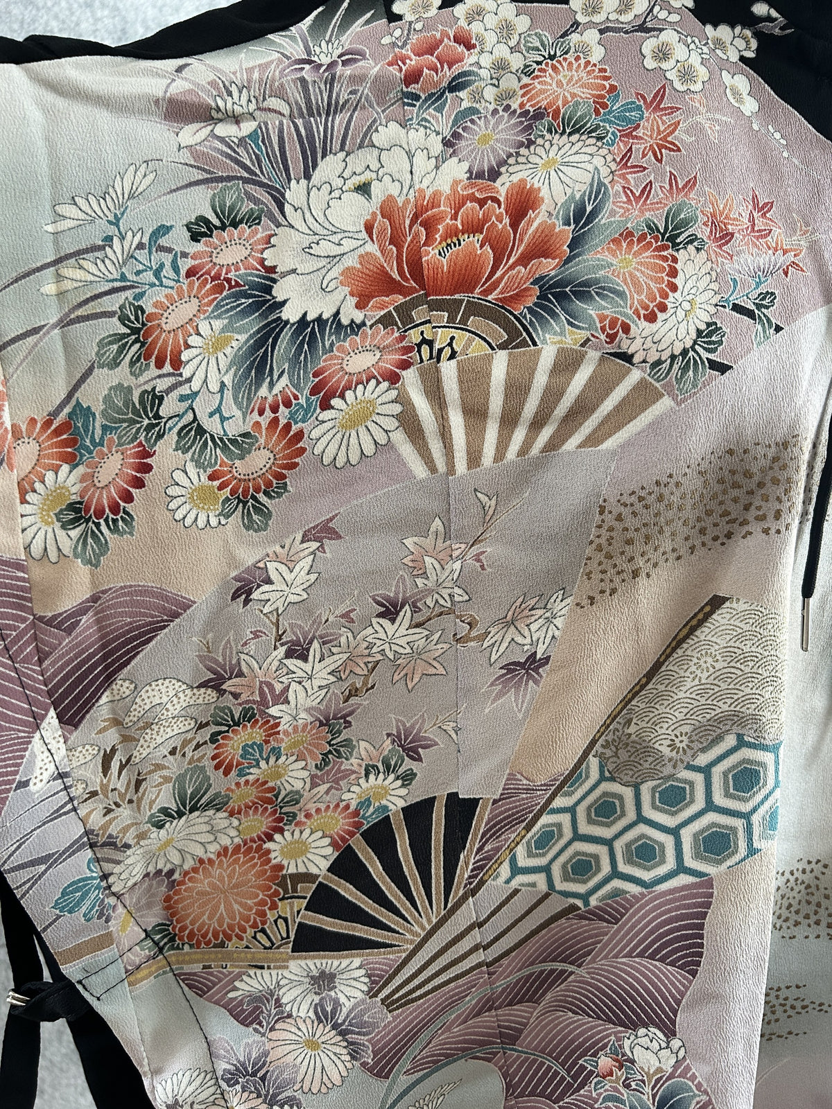 Black hooded kimono poncho, close-up of coral peonies, chrysanthemums and folding fans