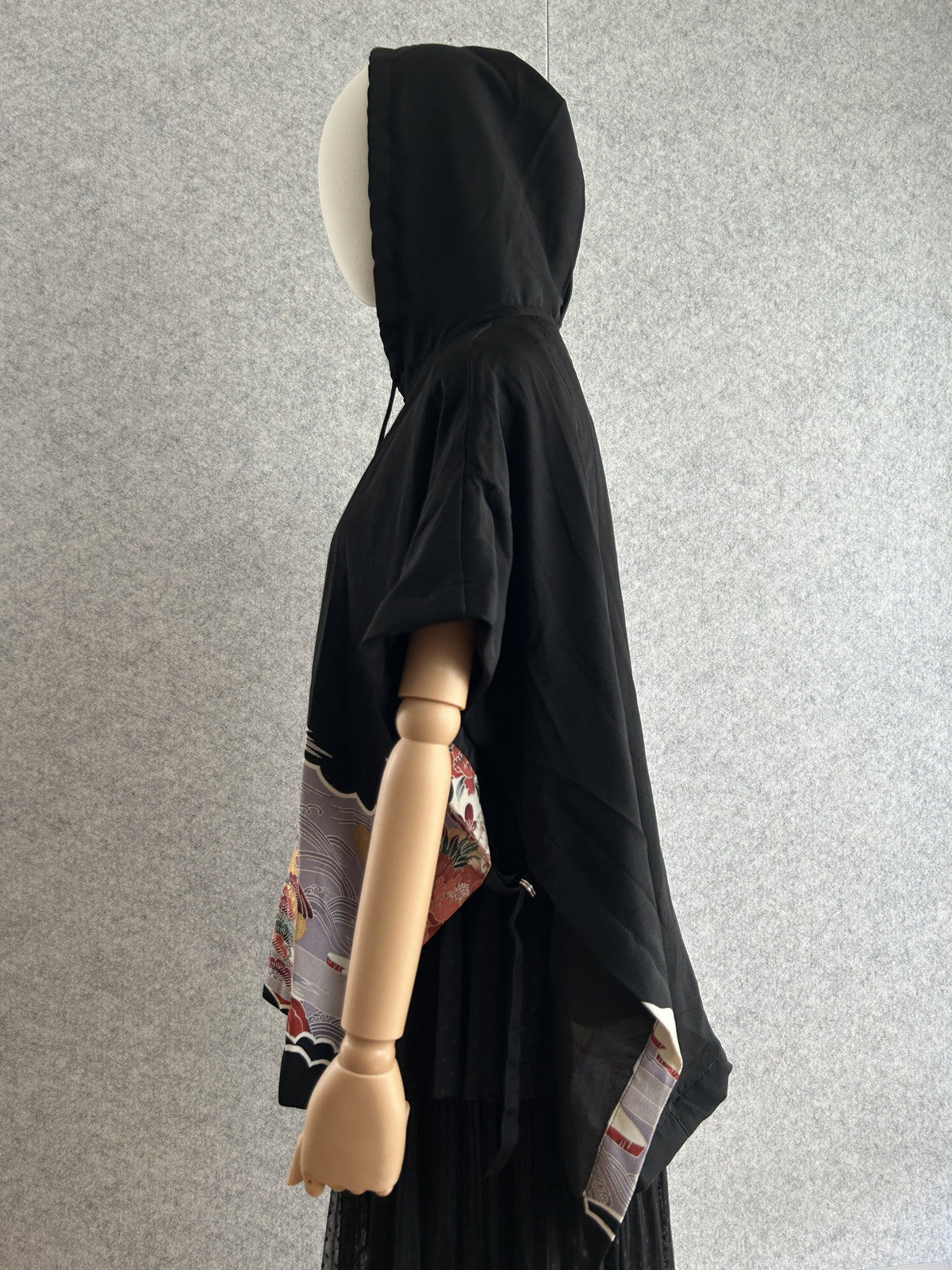 Black hooded kimono poncho with floral side panel, side view