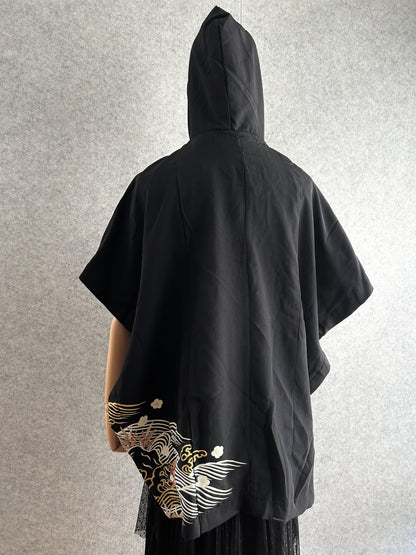 Black hooded kimono poncho, back view with small wave design at hem