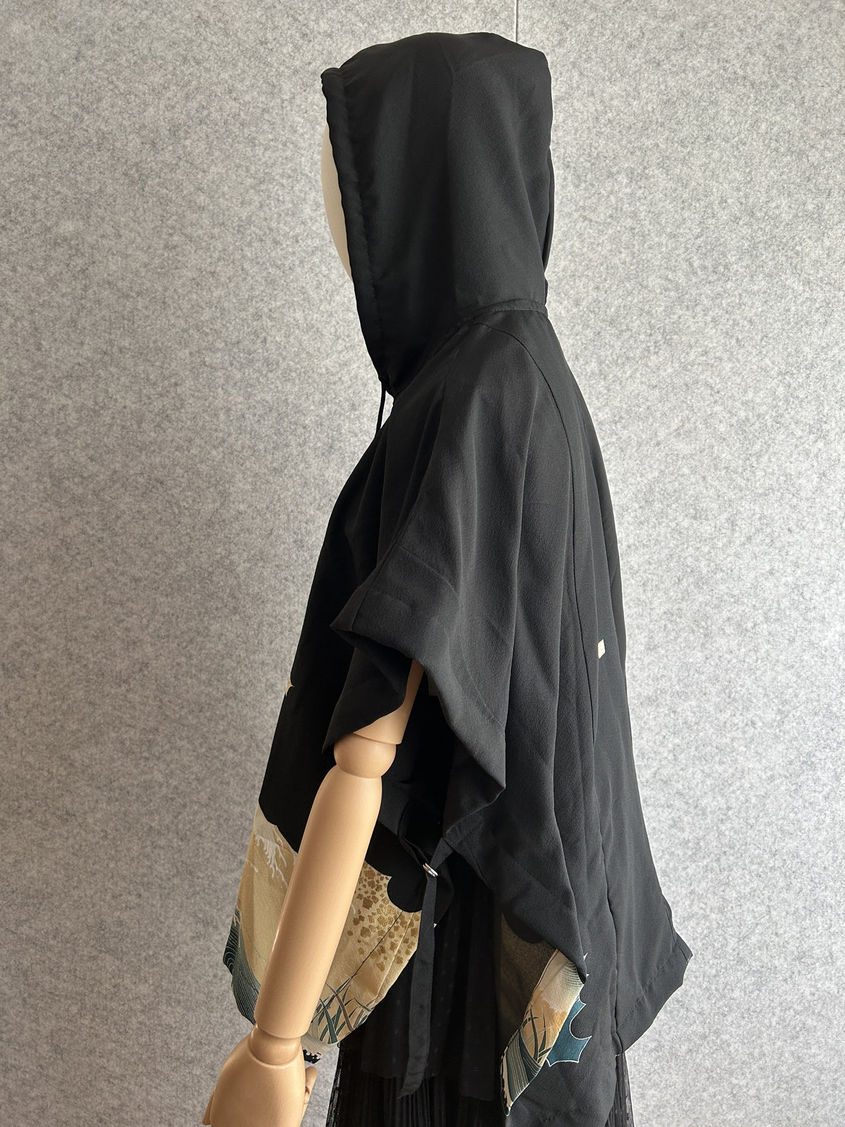 Black hooded kimono poncho with cream wave side panel, side view