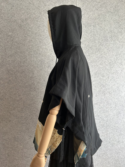 Black hooded kimono poncho with cream wave side panel, side view