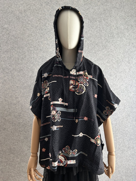 Black hooded kimono poncho with scattered ribbon and blossom pattern, front view