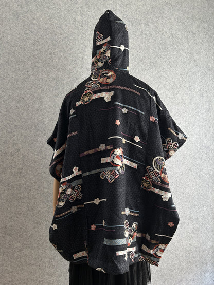 Black hooded kimono poncho with all-over ribbon and blossom pattern, back view