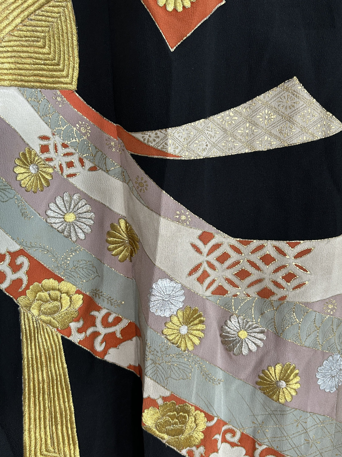 Ribbon bands with gold and silver flowers on black kimono skirt, detail