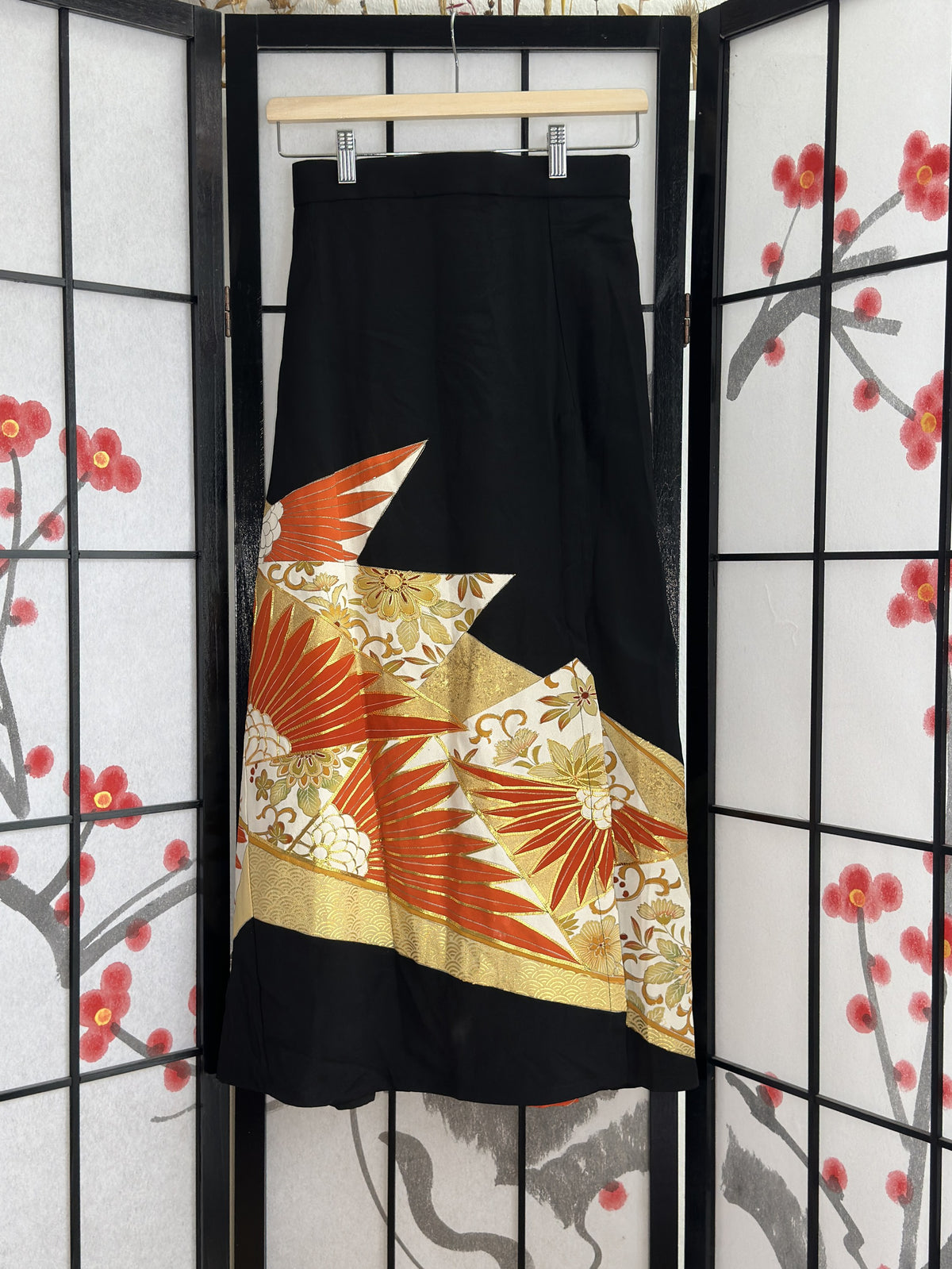 Black high slit kimono skirt with orange and gold design, front view