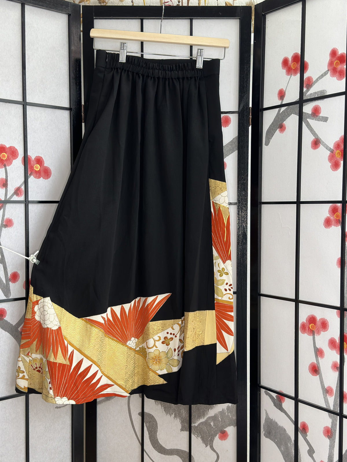 Black kimono skirt with elastic waistband and orange gold hem design, back view