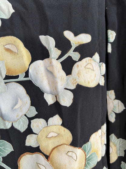 Round yellow and pale blue blossoms on black kimono skirt, close-up