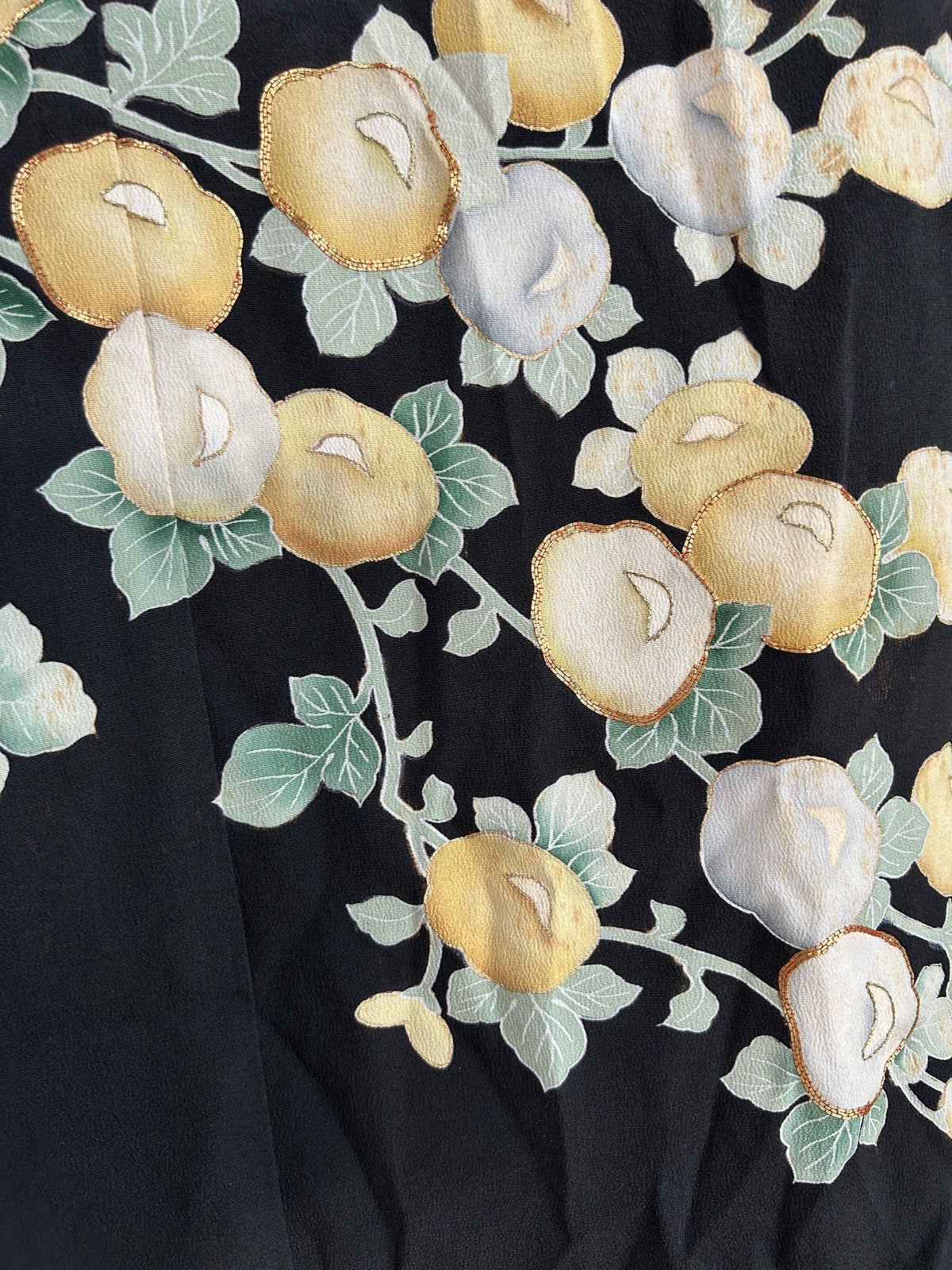 Blossom branches with green leaves on black kimono skirt, detail
