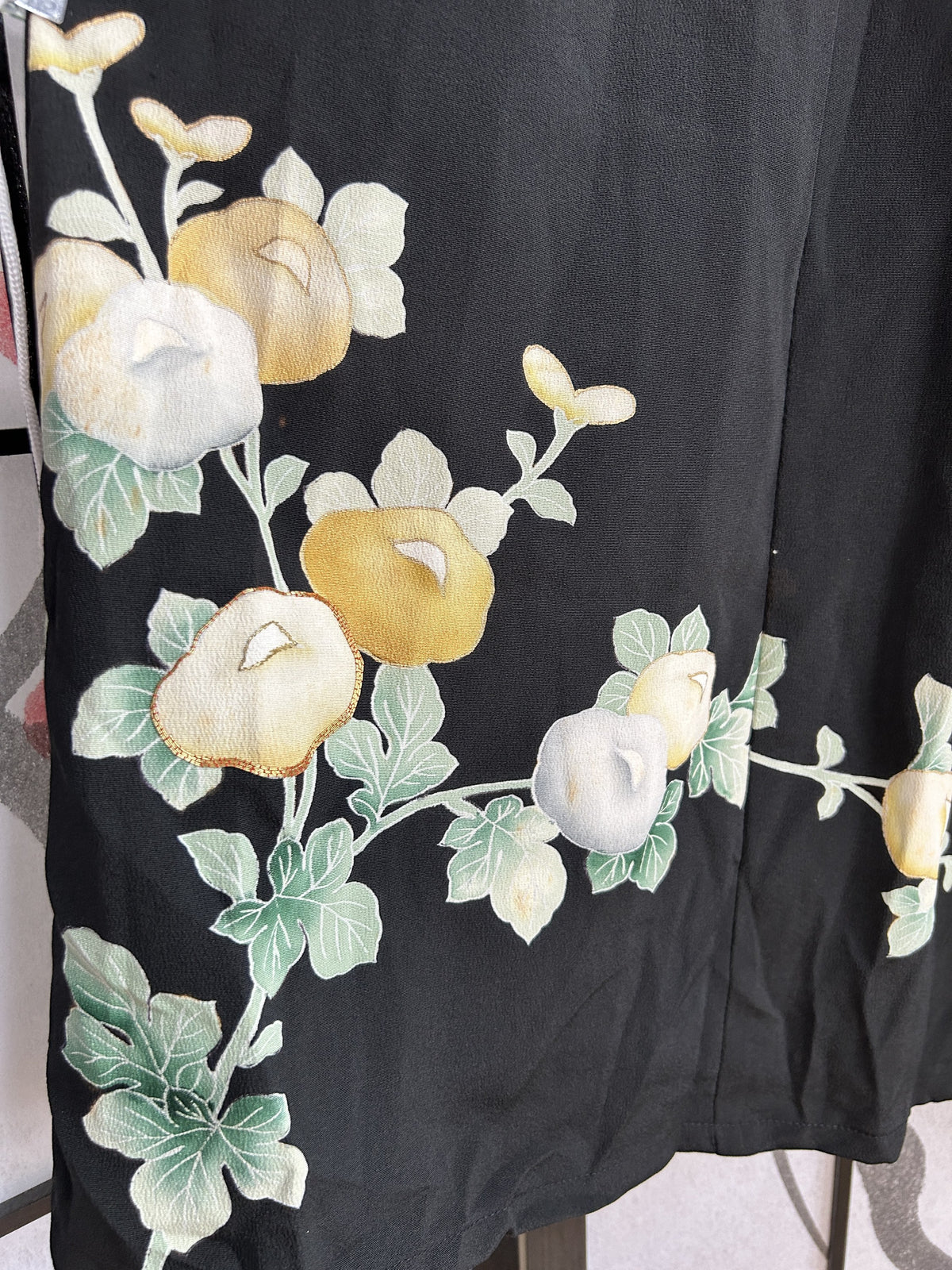 Yellow and white blossoms with leaves near the skirt hem, detail