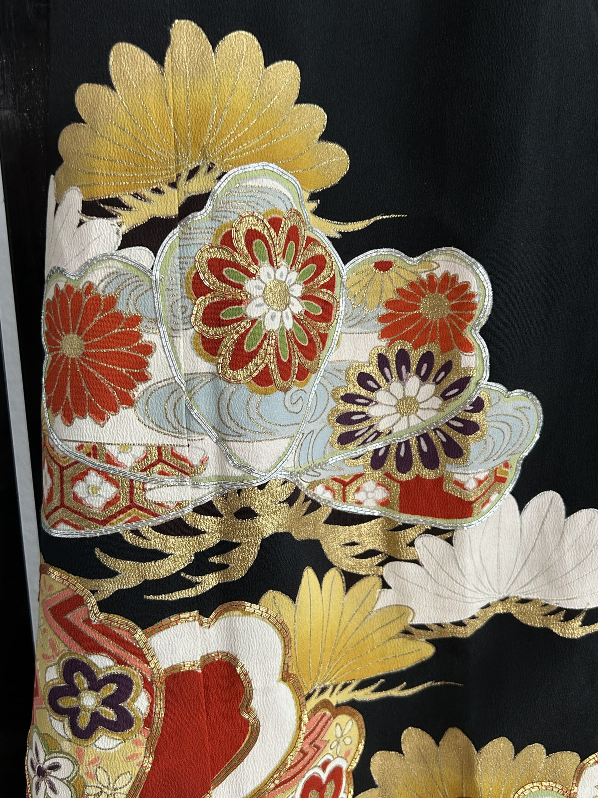 Red and gold flower-filled shapes with gold tufts on black skirt