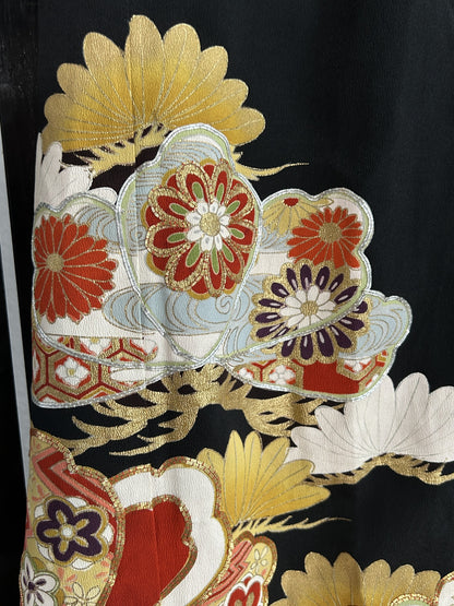 Red and gold flower-filled shapes with gold tufts on black skirt