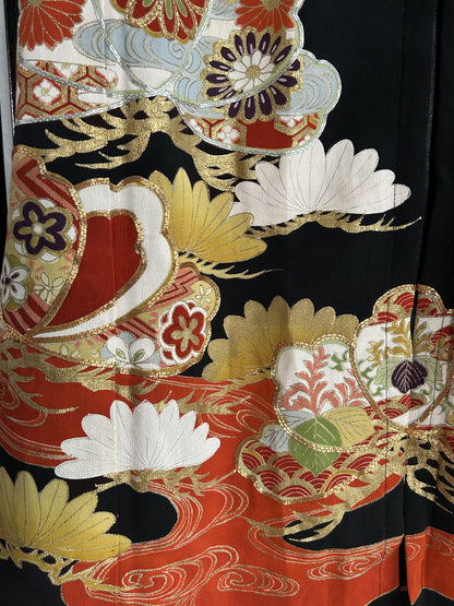 Red, white and gold motifs above red hem band, skirt detail