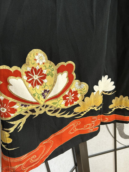 Red and gold floral motif with red swirl band near hem
