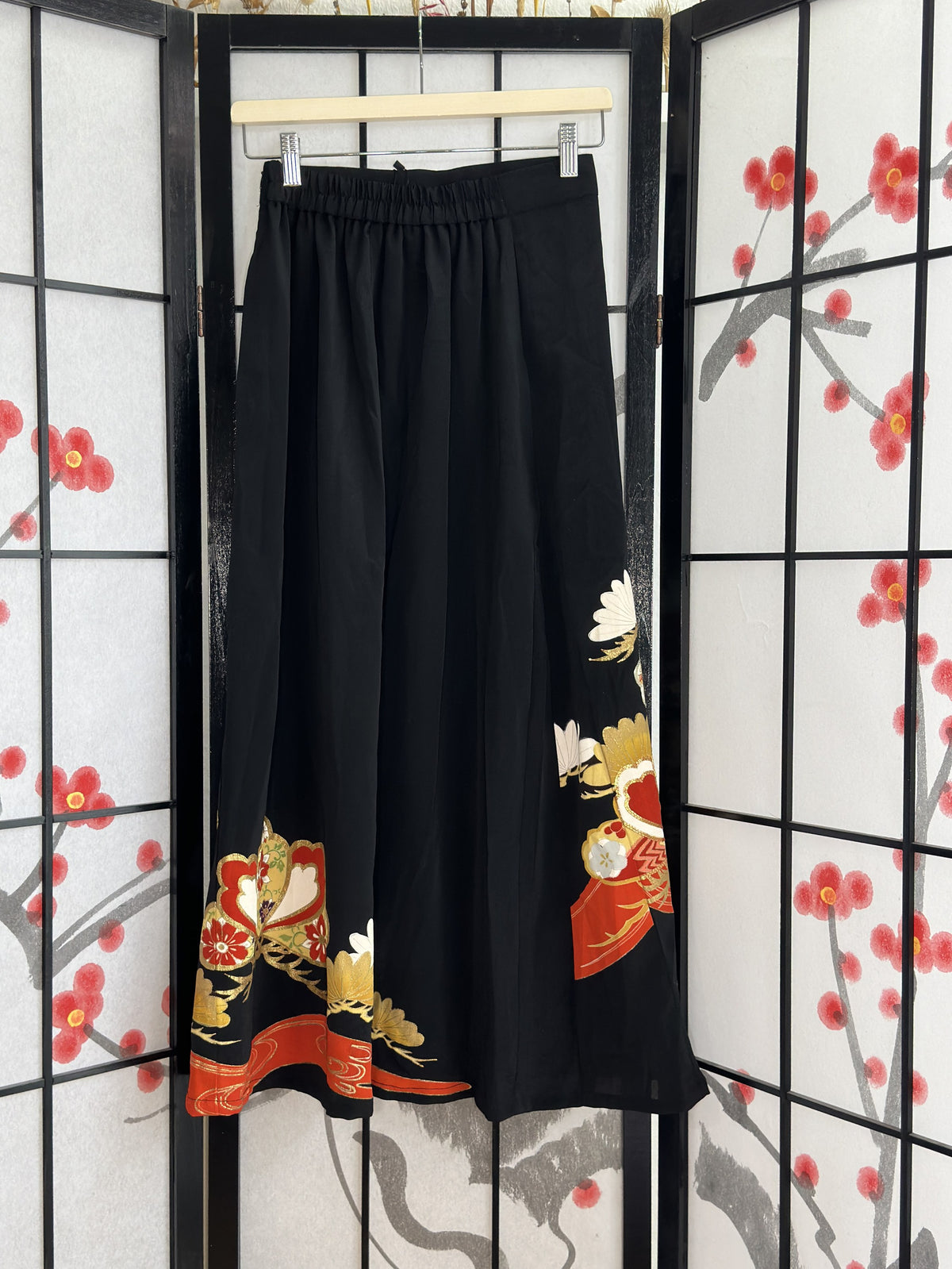 Black kimono skirt with elastic waistband and red gold hem, back view