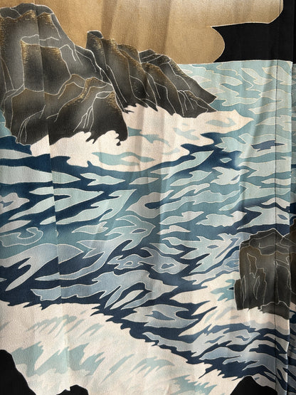 Blue and white waves with grey rocks on kimono skirt, close-up