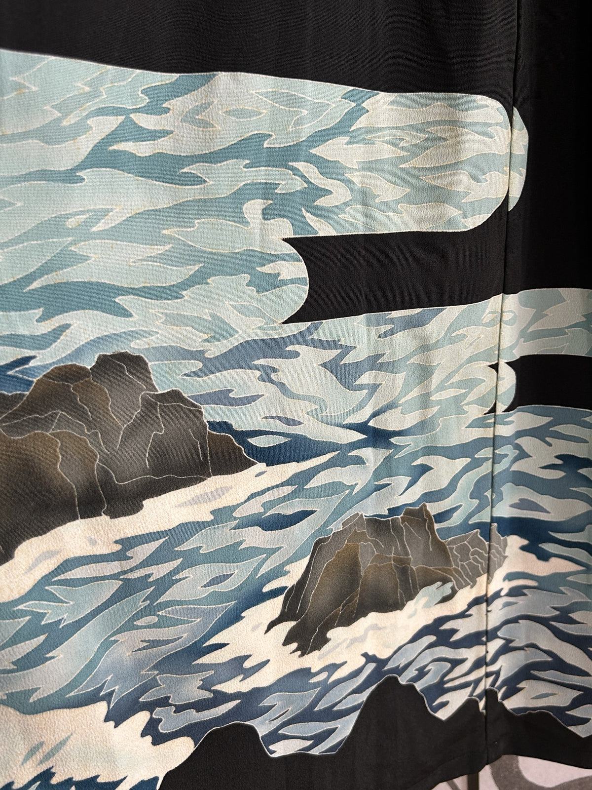Blue wave pattern with rocks on black kimono skirt, detail