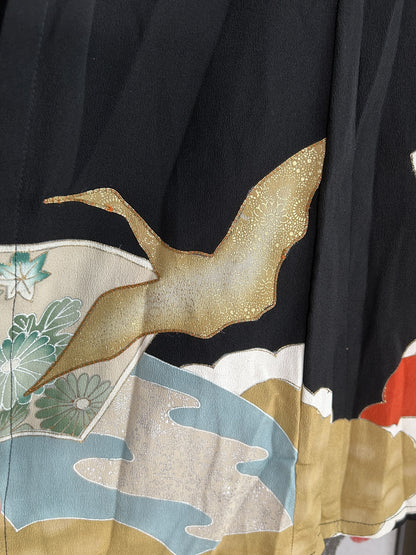 Gold flying bird above blue and beige shapes near skirt hem