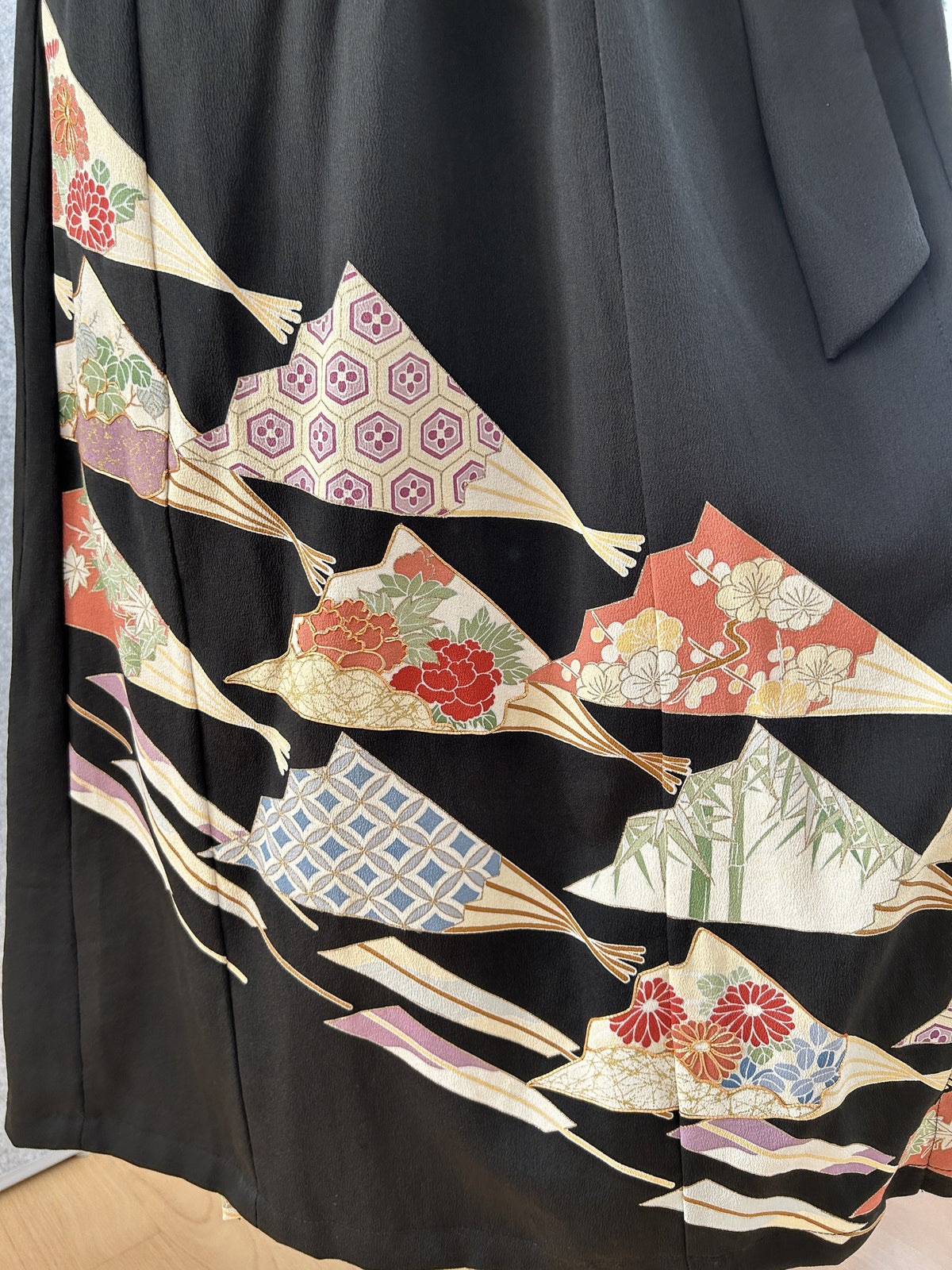 Black kimono dress skirt with colourful fan-shaped floral motifs near the hem
