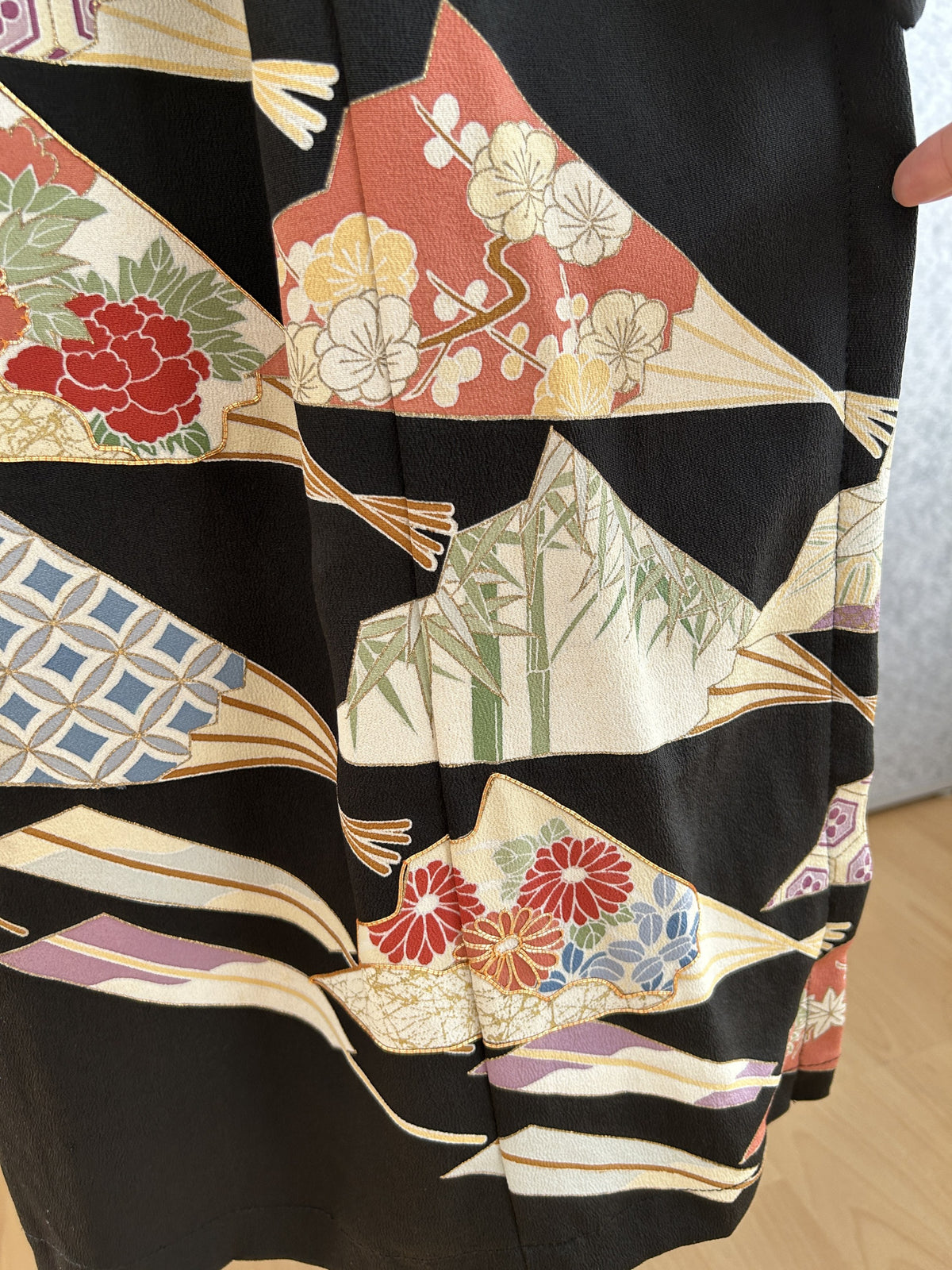 Black kimono dress, detail of fan motifs with flowers and bamboo