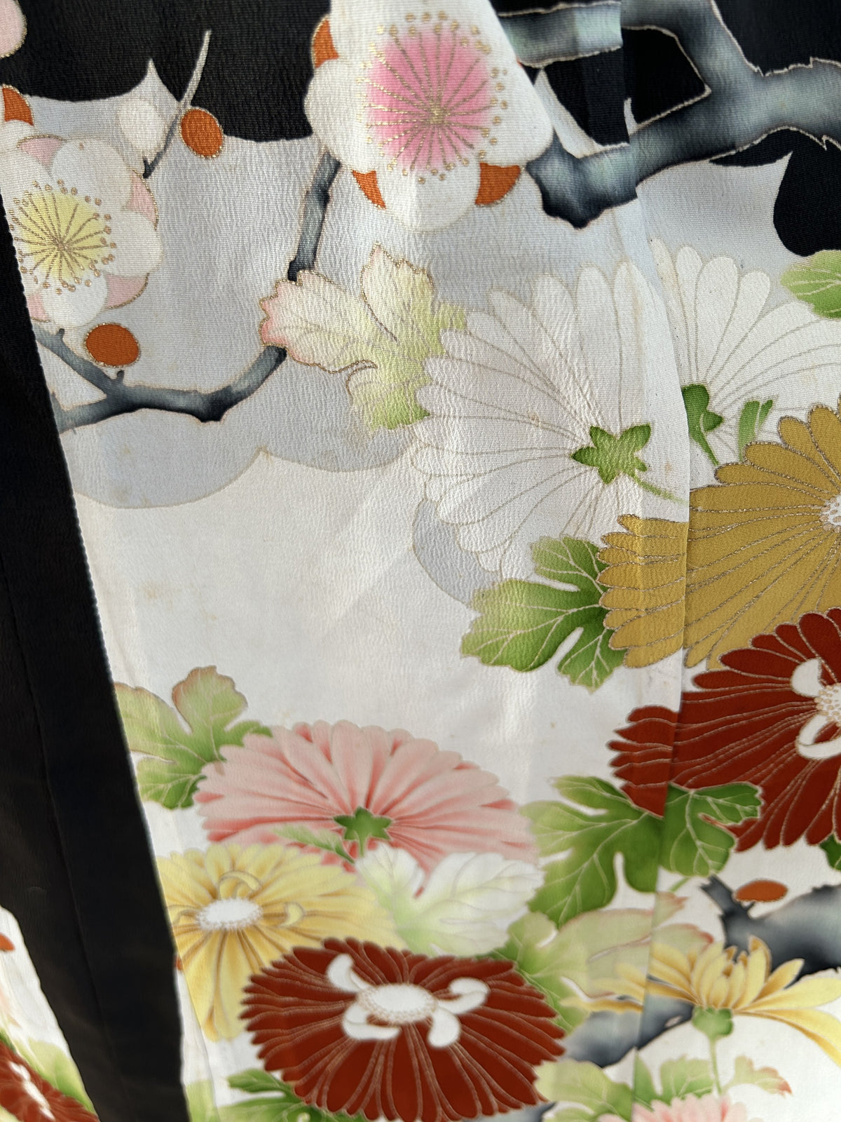 Black kimono dress, detail of white blossoms and chrysanthemums on skirt panel