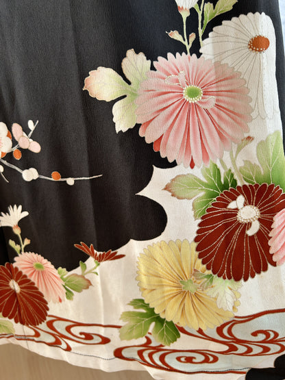 Black kimono dress, detail of pink chrysanthemum and red swirl hem border