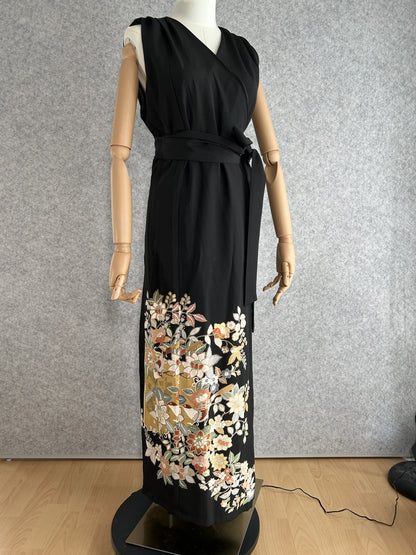 Black sleeveless kimono wrap dress with tie belt and floral hem, front view