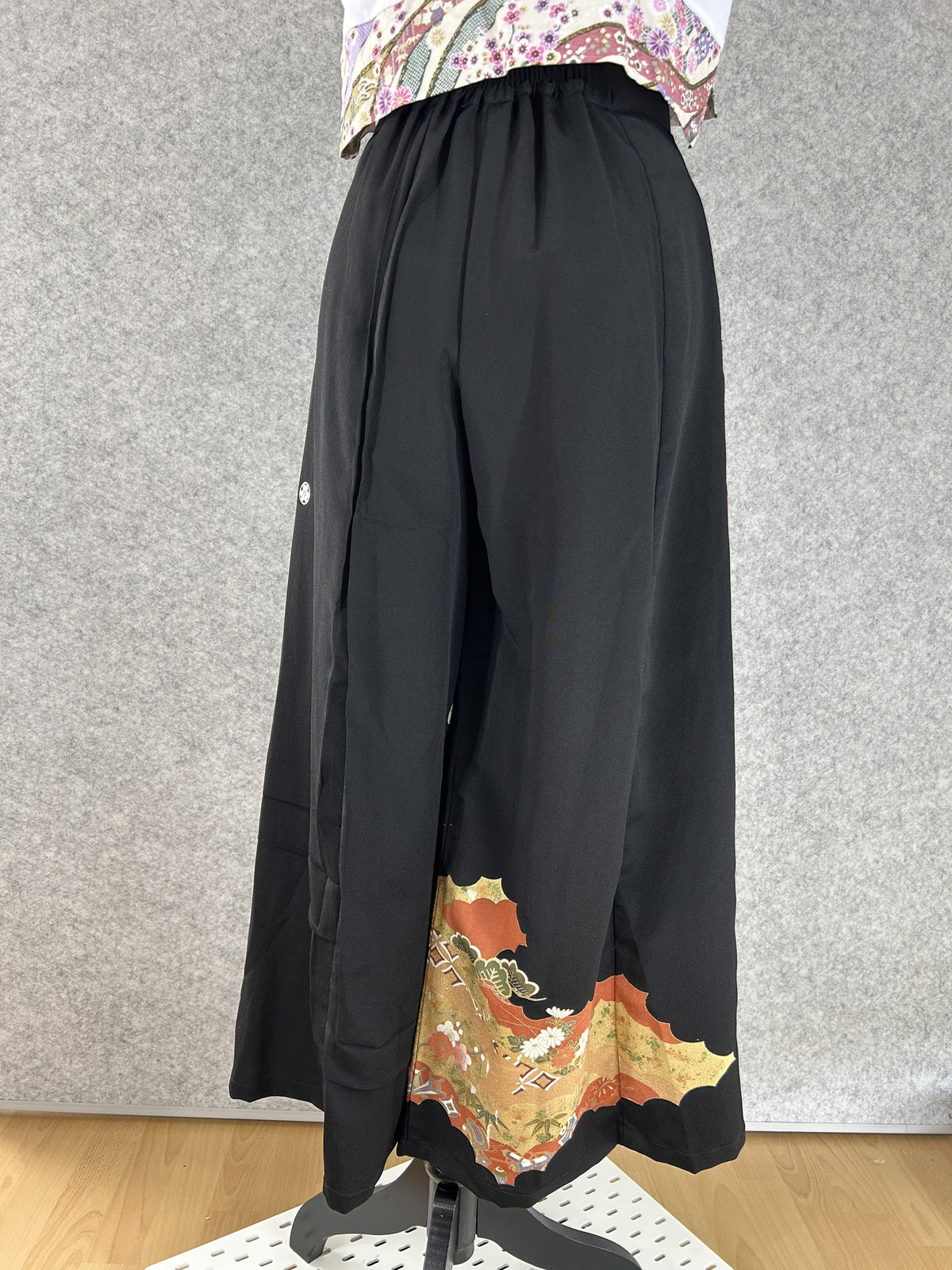 Black upcycled kimono palazzo pants with small white crest and cloud panels at the hem, back view