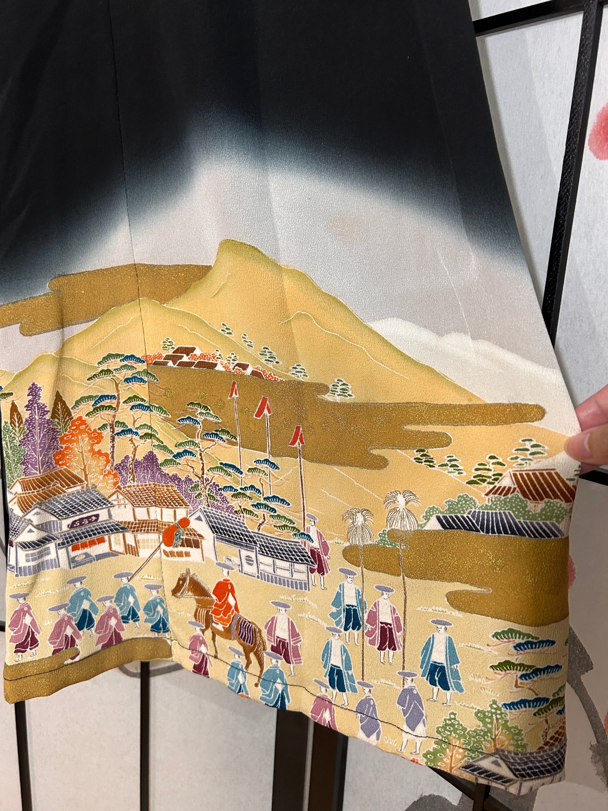 Traditional Japanese kimono with intricate patterns on a wooden floor.