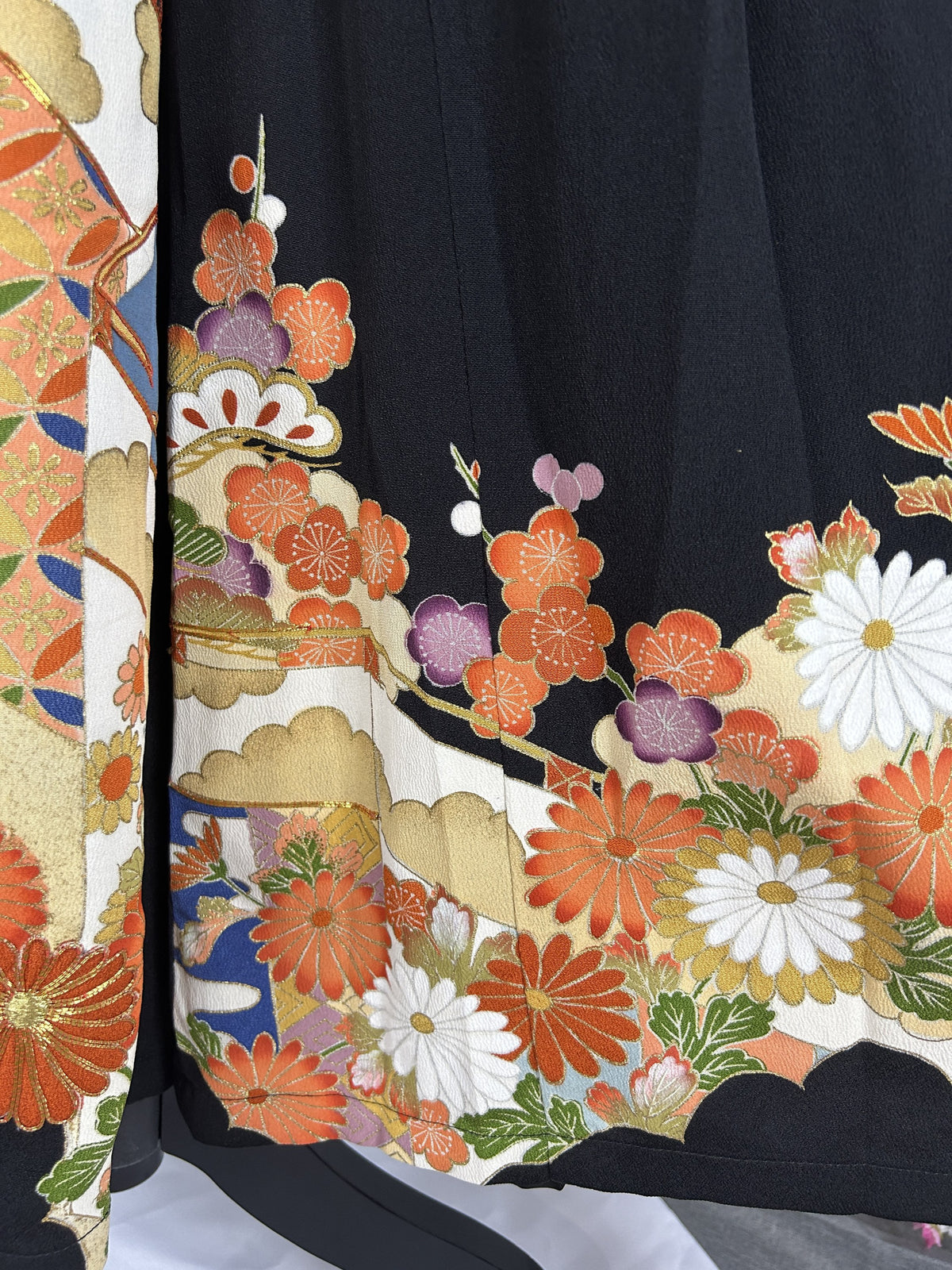 Black upcycled kimono palazzo pants, close-up of the hem with orange and white chrysanthemums