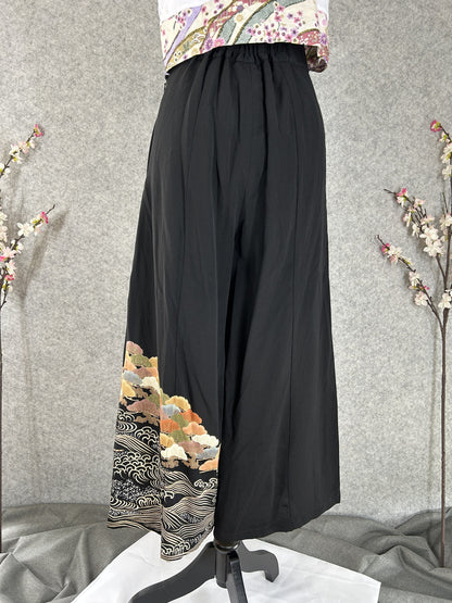 Black upcycled kimono palazzo pants with trees and waves at the hem, back view