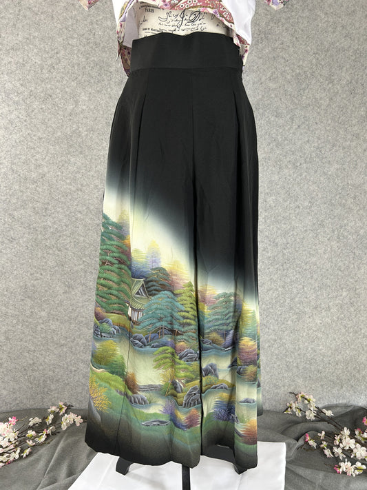 Black upcycled kimono palazzo pants with pale landscape of pines and a house at the hem, front view