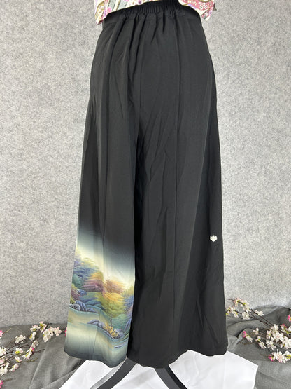 Black upcycled kimono palazzo pants with small white crest and landscape hem, back view
