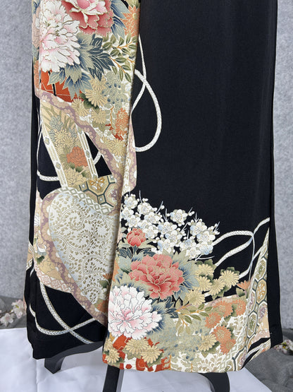 Black upcycled tomesode kimono wide leg pants with peonies, plum blossoms and white cords, close-up of the hem with plum blossoms and cords