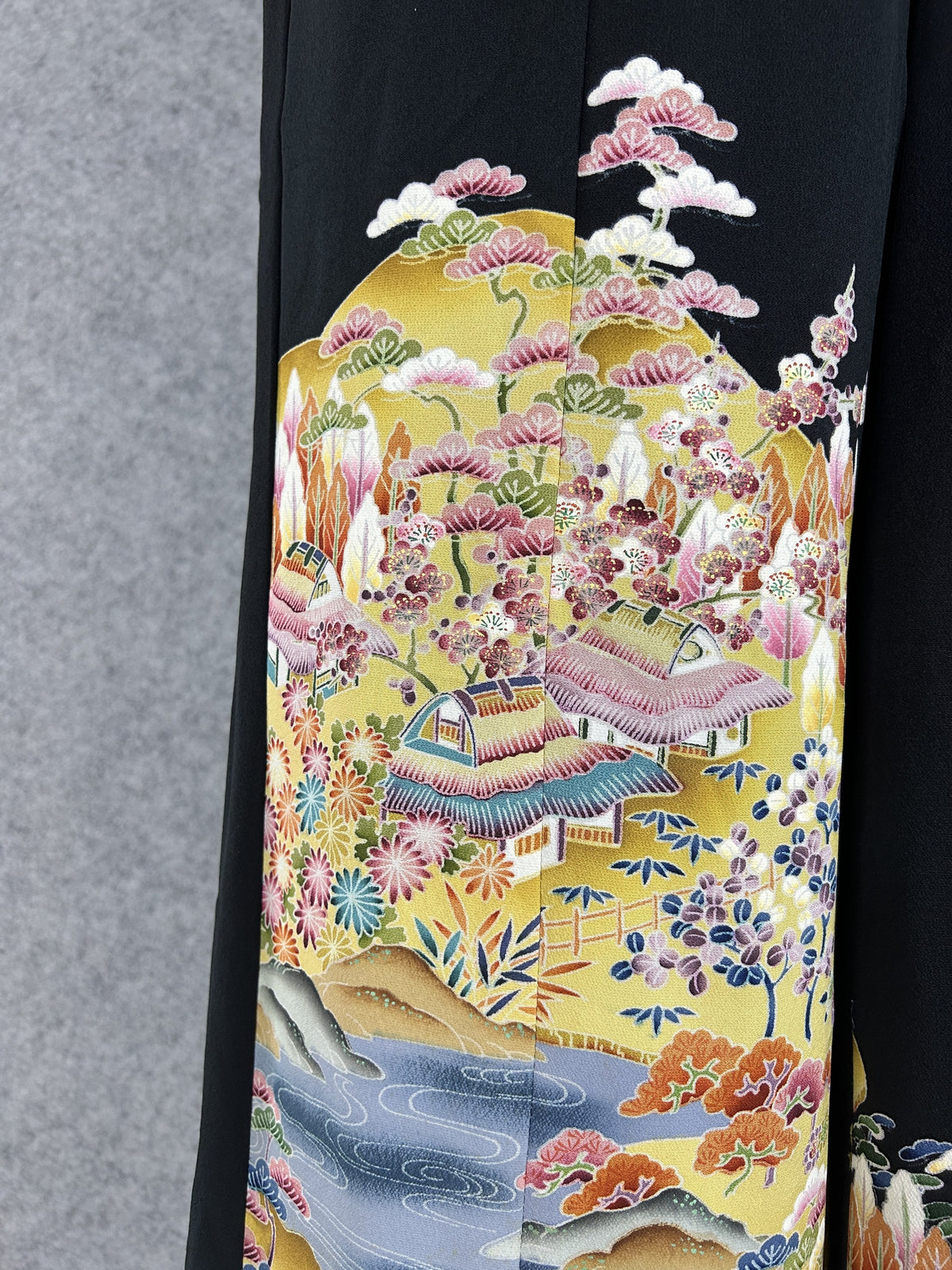 Black upcycled tomesode kimono wide leg pants with a golden village landscape, detail of the golden landscape on the left leg