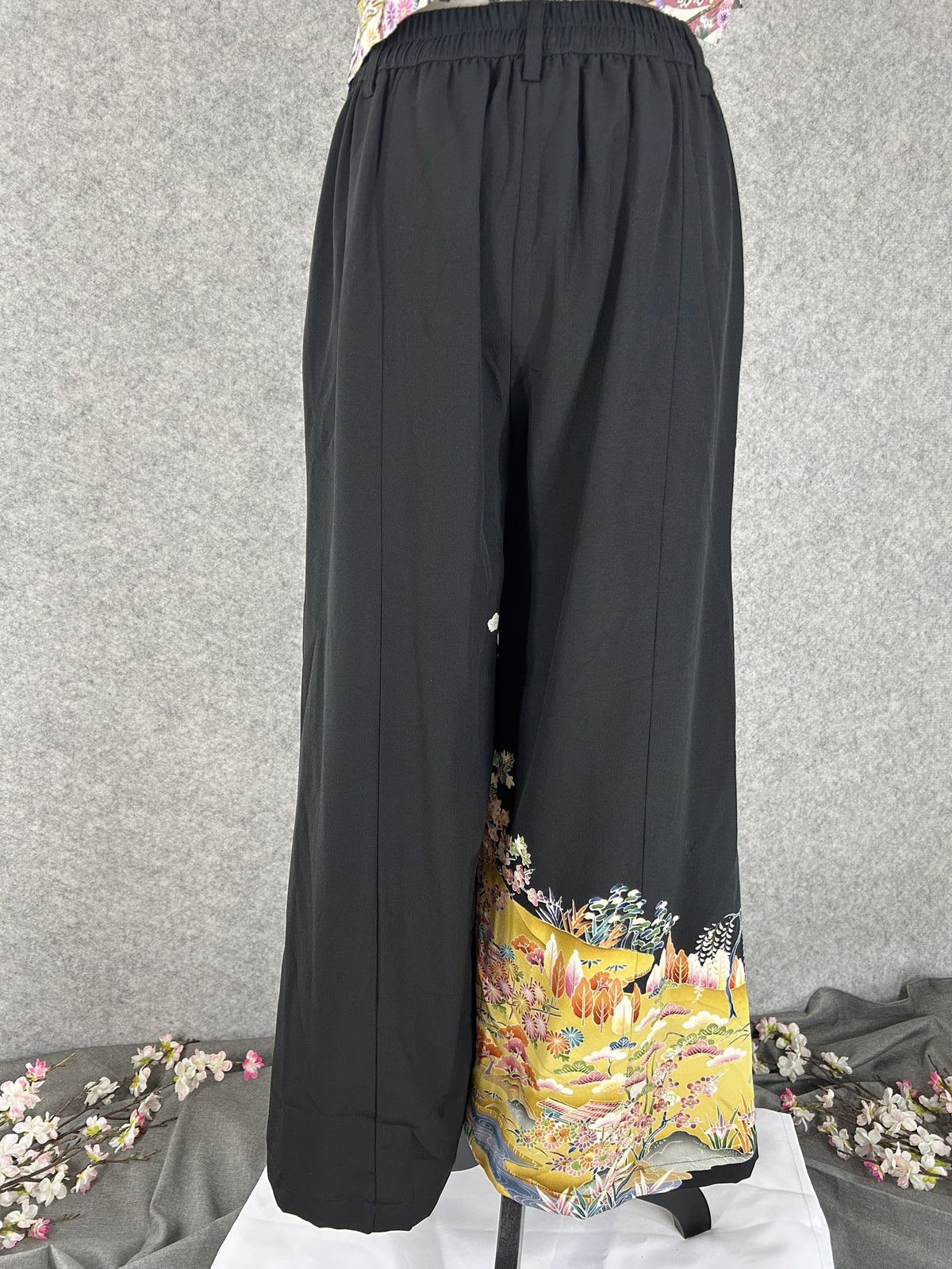 Black upcycled tomesode kimono wide leg pants with a golden village landscape, back view with elastic waistband