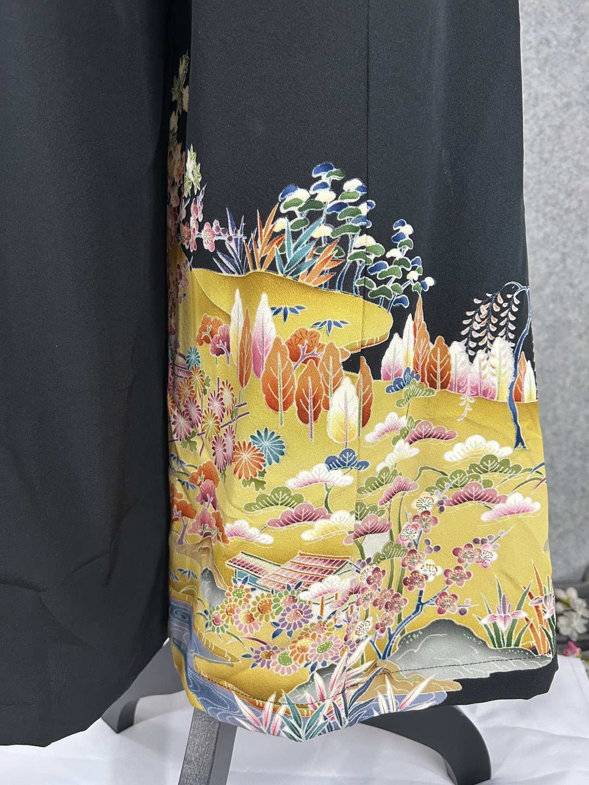 Black upcycled tomesode kimono wide leg pants with a golden village landscape, detail of the landscape at the back hem
