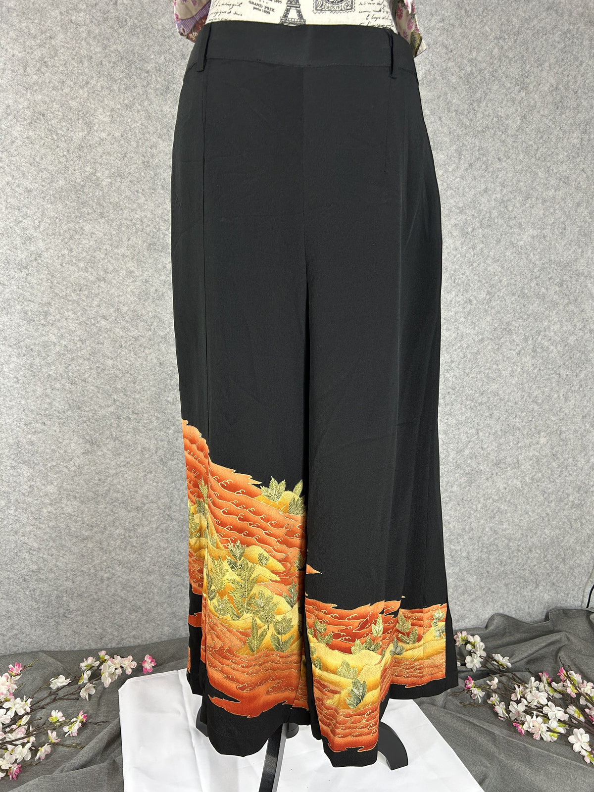 Black upcycled tomesode kimono wide leg pants with orange and gold waves, front view