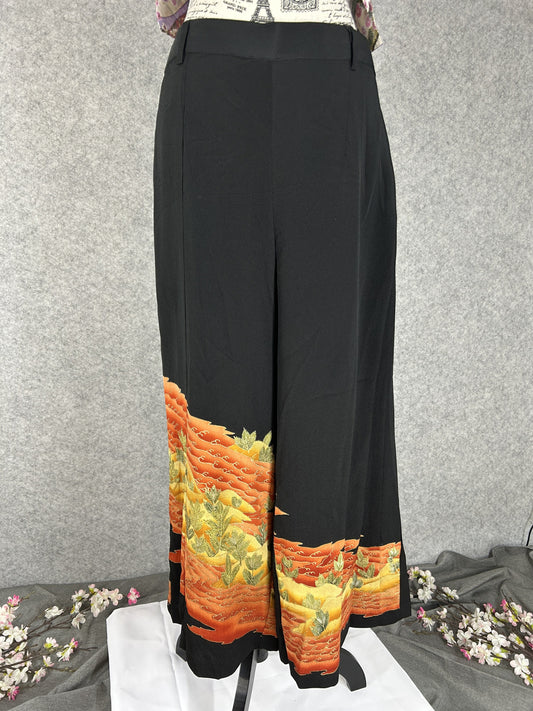 Black upcycled tomesode kimono wide leg pants with orange and gold waves, front view