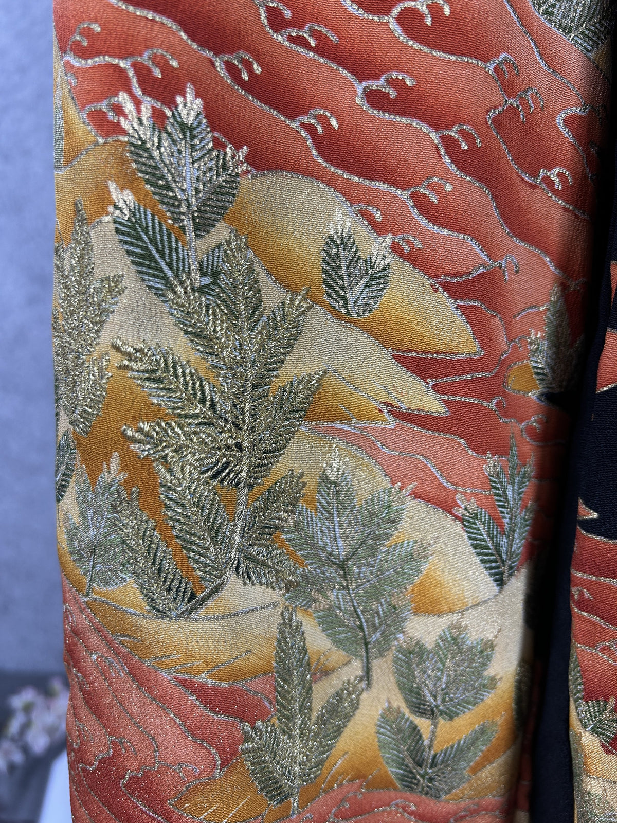 Black upcycled tomesode kimono wide leg pants with orange and gold waves, close-up of the embroidered pine detail