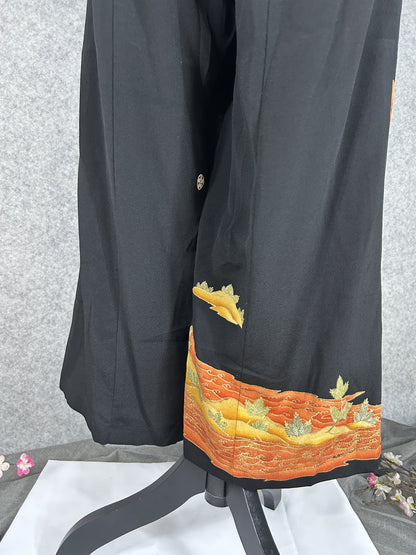 Black upcycled tomesode kimono wide leg pants with orange and gold waves, back view