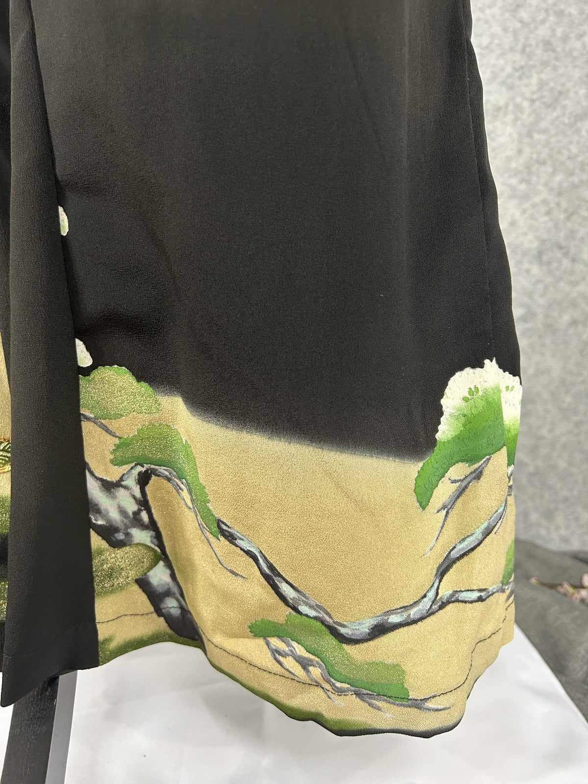 Black upcycled tomesode kimono wide leg pants with a pine tree on gold, close-up of the gold hem with pine branches