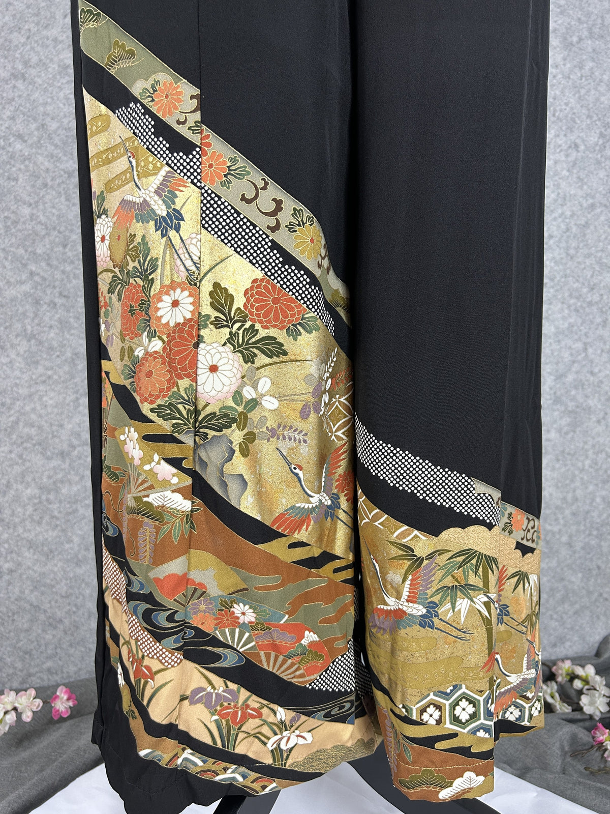Black upcycled tomesode kimono wide leg pants with gold bands, cranes and chrysanthemums, detail of the gold hem with chrysanthemums